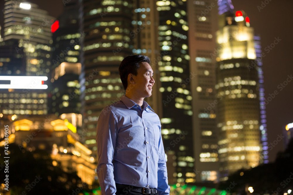 Chinese businessman standing outdoors at night.