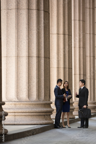 Asian business colleagues outside a Colonial building.
