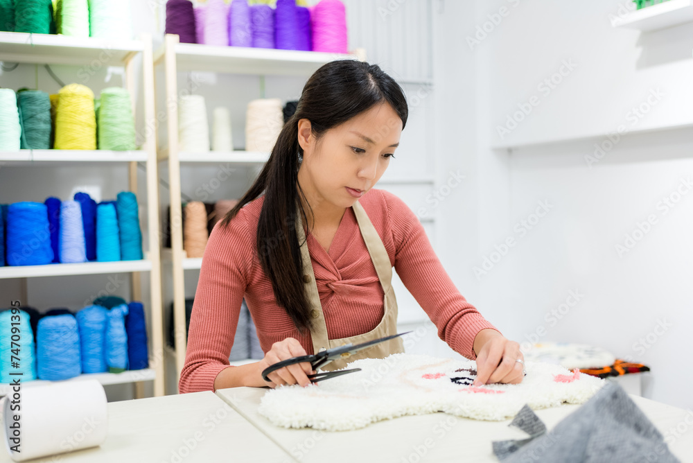 Woman choose the color of thread for making of tufting carpet at studio