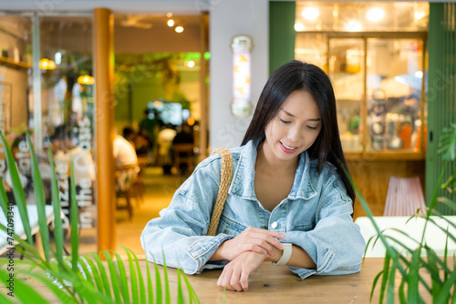 Woman look at the smart watch in cozy cafe