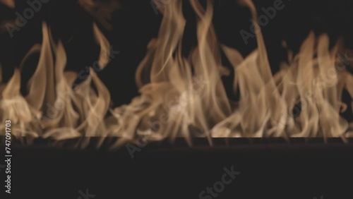 Fire burning. Bright burning flames on a black background. Fire in slow motion. Wall of Real fire, abstract background. Slow motion video, ProRes 422, ungraded C-LOG 10 bit color. photo