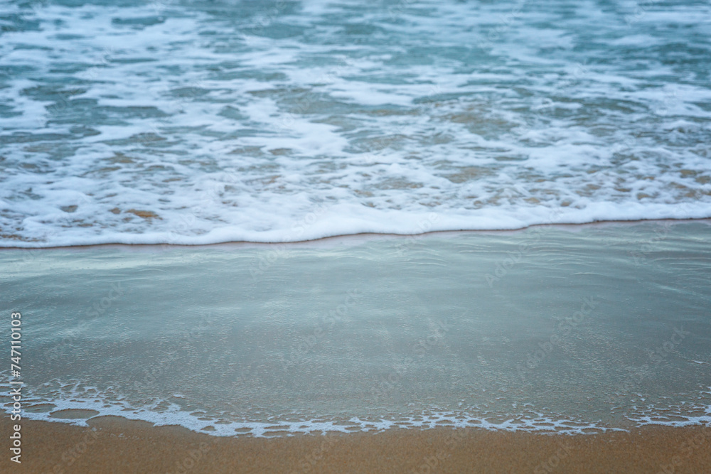 Foam wave on the sandy shore. Relaxation at the resort and activity in nature. Background. Space for text. Foam wave on the sandy shore. Relaxation at the resort and activity in nature. Background. Space for text.