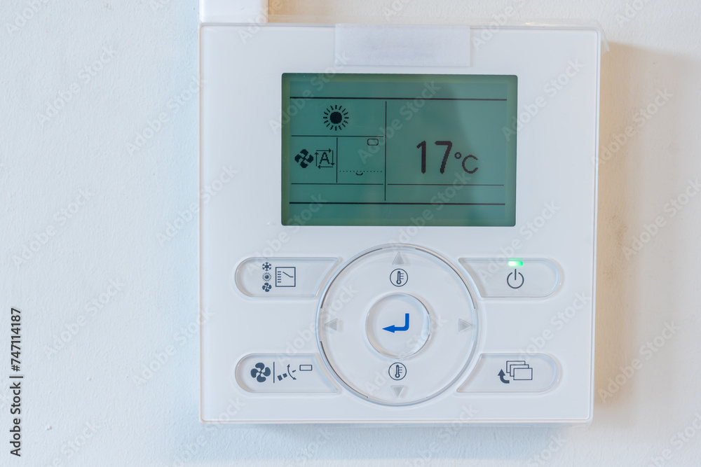 air conditioner remote panel on the wall,control thermostat mounted on white wall, heating control panel air conditioner remote panel on the wall,control thermostat mounted on white wall, heating control panel
