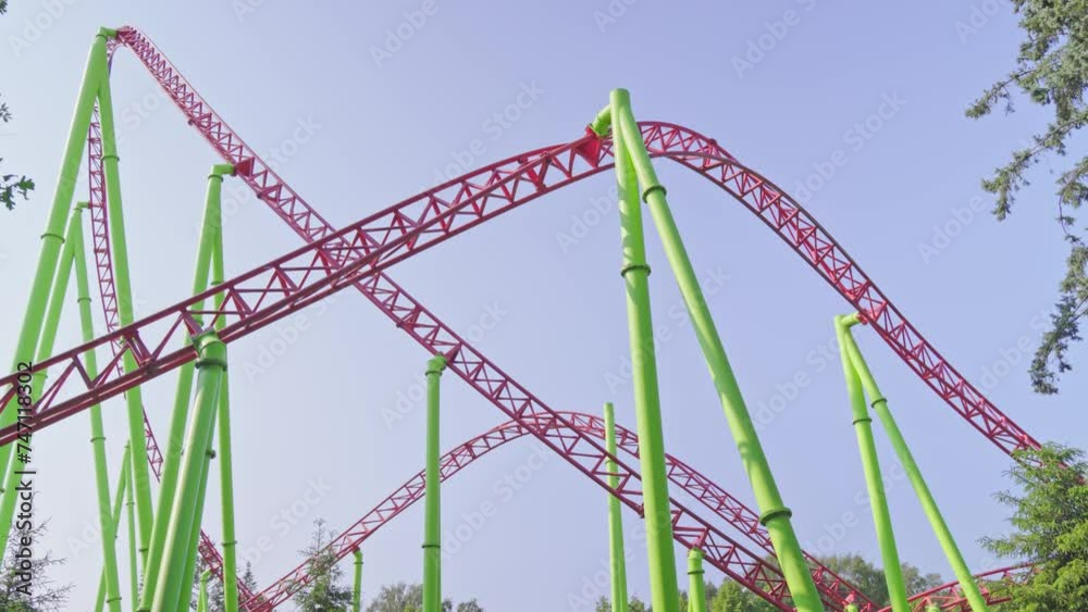 Roller coaster Ride against blue sky. Roller coaster in the amusement park. Cheerful entertainments in park of attractions
