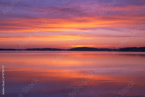 Scenic view of sunset with pink sky reflected in water © Wirestock