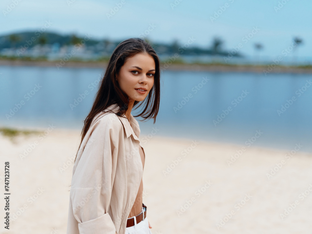 Serene Summer: A Beautiful Young Woman Enjoying a Carefree Day at the Beach, Gazing at the Ocean and Embracing the Joy of Life
