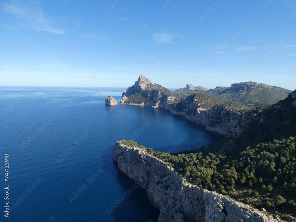 Rocky sea coast with mountains in the background in Mallorca, Spain