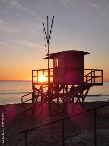 Silhouetted lifeguard tower at sunset in Mallorca, Spain