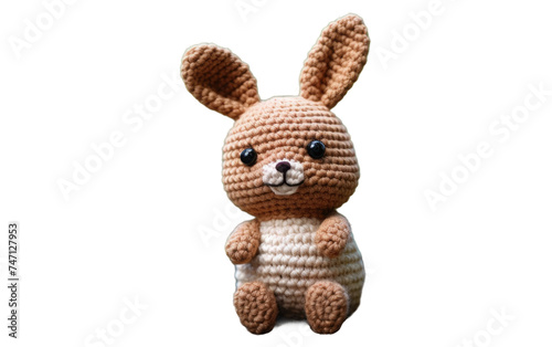 Crocheted Bunny. A crocheted bunny figurine is positioned neatly on a smooth. The bunny appears to be sitting upright with its legs folded underneath it. Isolated on a Transparent Background PNG.