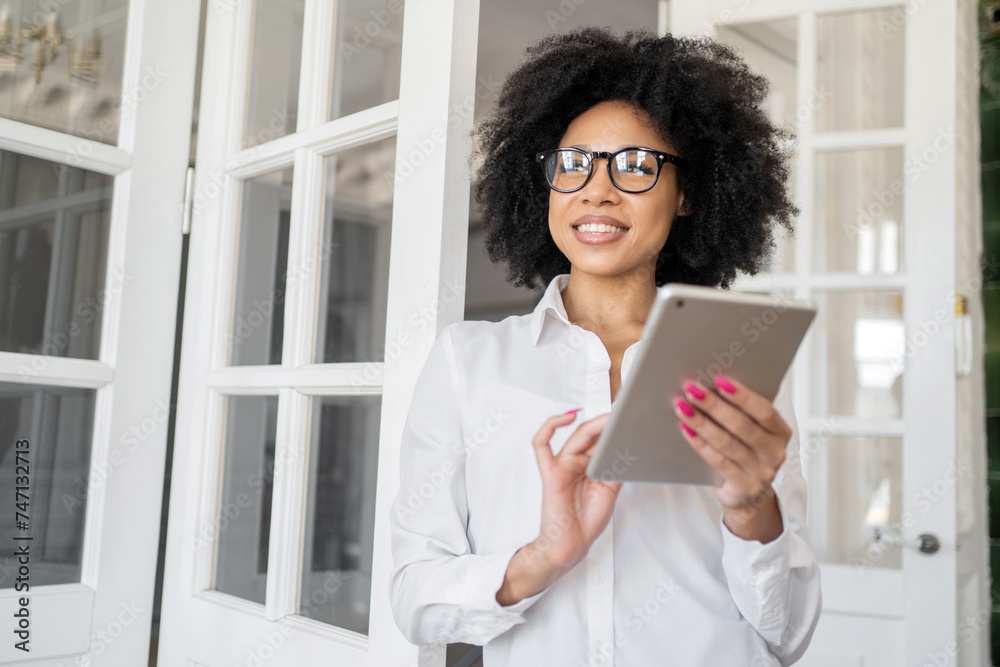 Cheerful businesswoman using tablet in a well-lit interior space. Cheerful businesswoman using tablet in a well-lit interior space.