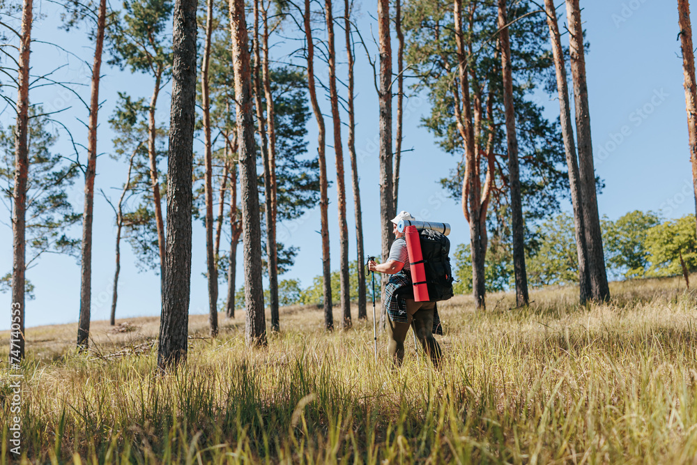 Woman with a backpack showcases the power of a healthy lifestyle, trekking through nature Woman with a backpack showcases the power of a healthy lifestyle, trekking through nature