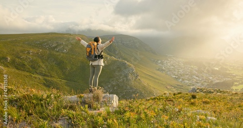 Woman, mountain top and freedom, hiking goals, celebration or travel achievement in nature adventure. Person or winner in backpack with arms up for trekking success, energy and yes on a cliff or rock
