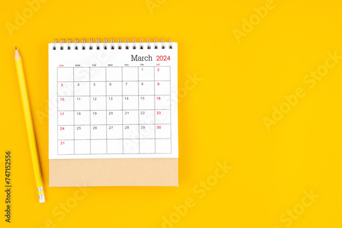 March 2024 desk calendar and wooden pencil on yellow color background.