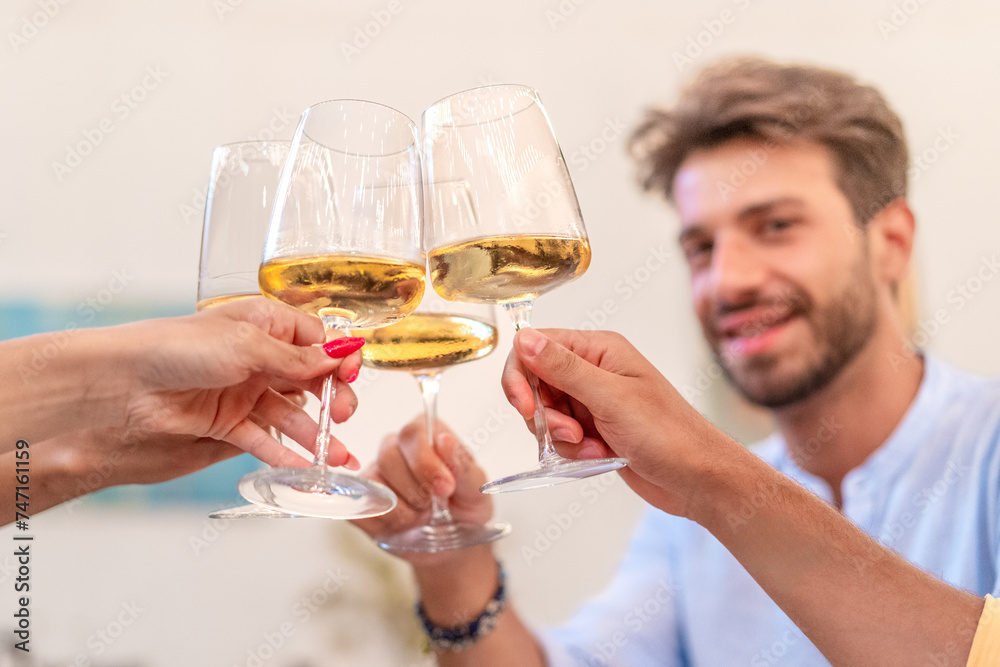 A group of friends comes together, raising their glasses of white wine in a toast to celebrate a momentous occasion, embodying the spirit of companionship and good cheer. A group of friends comes together, raising their glasses of white wine in a toast to celebrate a momentous occasion, embodying the spirit of companionship and good cheer.