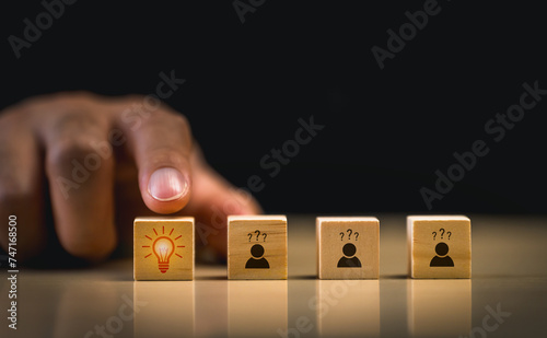 Conceptual idea and innovation wooden blocks. Finger pushing a wooden block with a light bulb icon, concept for idea and innovation, signifying the choice of innovation among options of uncertainty.