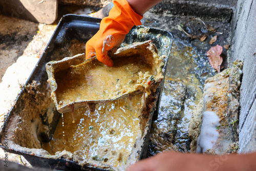 Grease traps from dirty debris being cleaned with a scoop are discarded. How to treat water with a grease trap. photo