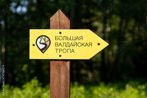 Great Valdai Trail, Valdai National Park, Novgorod region, Russia - June 8, 2023. Signpost with text in Russian “Great Valdai Trail”. Tourist ecological trail in the forest. Hiking and traveling.