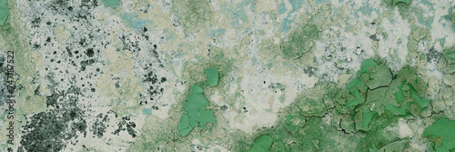 Peeling paint on the wall. Panorama of a concrete wall with old cracked flaking paint. Weathered rough painted surface with patterns of cracks and peeling. Wide panoramic texture for grunge background