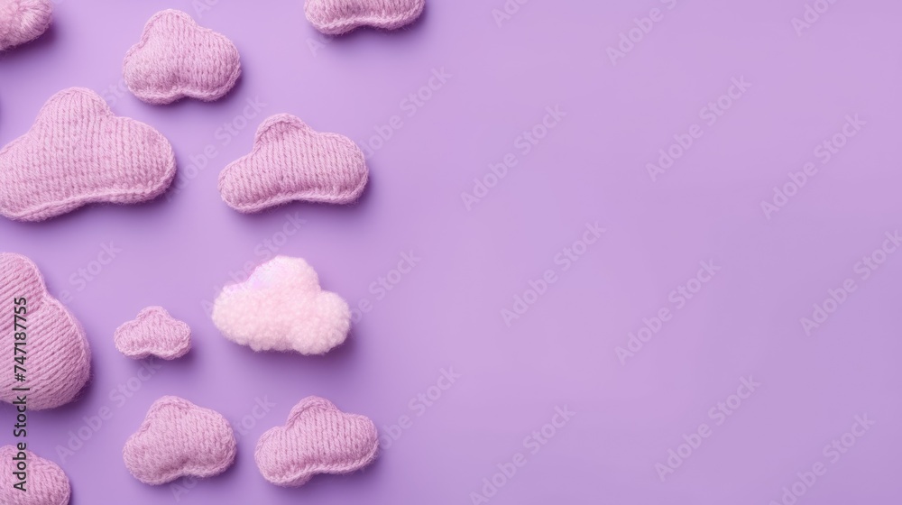 Knitted toy pink cloud on a purple background. Children's clothes and accessories. View from above.