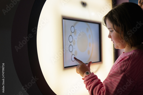 Young girl exploring interactive exhibit at a science museum photo