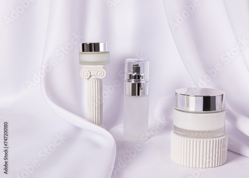 Stylish frosted glass cosmetic jars with silver lid with luxury cream and serum for face and body skin care. Natural care. beauty concept.
