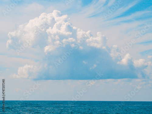 Magical seascape with a big lush cloud above the sea horizon.