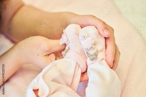 A woman's hand holds the baby's legs. A newborn baby.