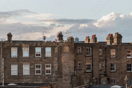 Photography Rear view of urban brick apartment buildings and old houses in london with sky background at evening