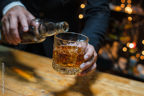 Barman pouring whiskey whiskey glass..