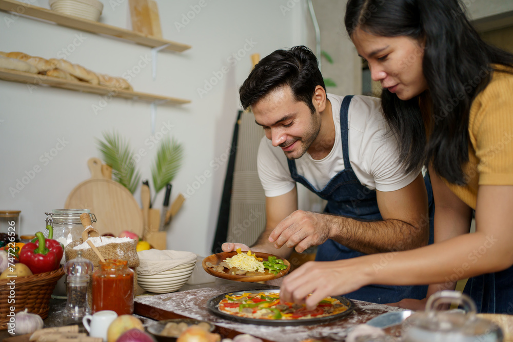 Man and woman making a pizza.