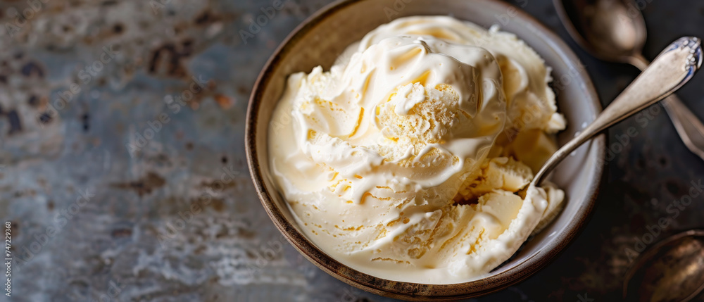 High angle view of delicious vanilla ice cream served in a ceramic bowl with vintage spoons on an old wooden table High angle view of delicious vanilla ice cream served in a ceramic bowl with vintage spoons on an old wooden table