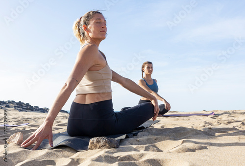 Beach Yoga Class at Sunset in Easy Pose