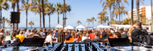 Beach party festival with dj mixing, outdoor crowd, blurred background, and space for text placement photo