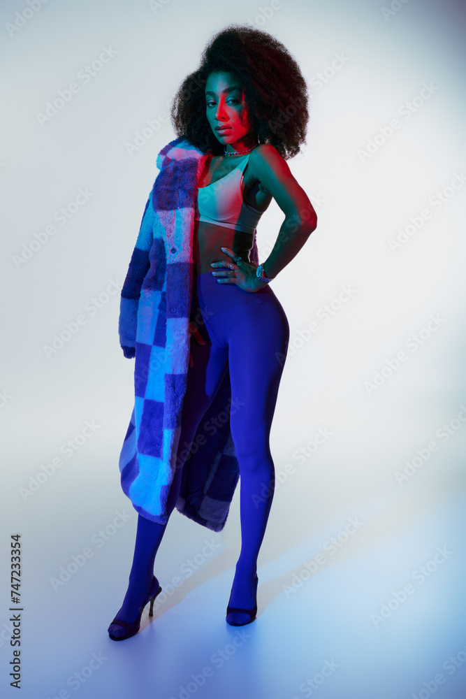 appealing sexy african american woman in fashionable stylish faux fur looking at camera in lights appealing sexy african american woman in fashionable stylish faux fur looking at camera in lights