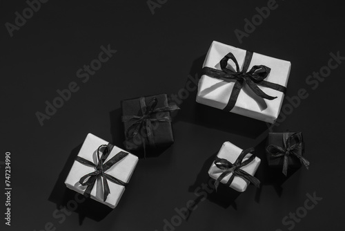 White and black gift boxes on a black background with space for text.Holiday shopping, sales. Presents for men.