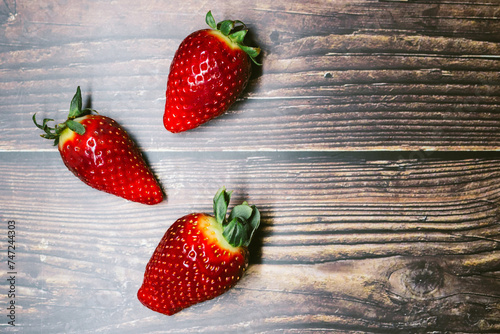 ripe strawberry berries on a dark wooden background. space for your text