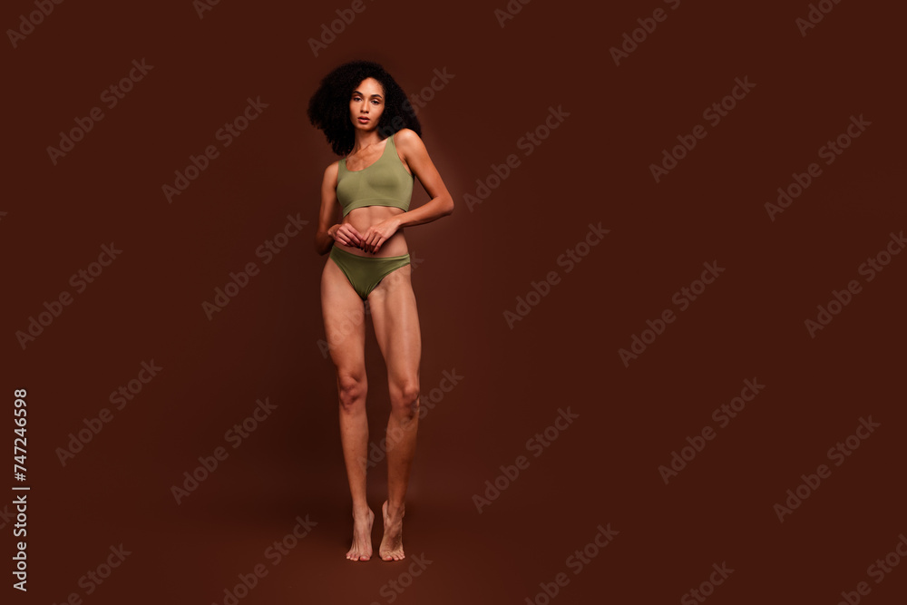 Fototapeta premium No filter photo of charming girl flawless athletic body thin waist standing barefoot empty space isolated on brown color background