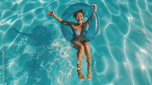 Smiling exited young woman in swimming pool floating on swimming ring