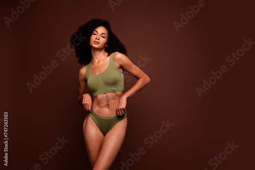 Studio no retouch photo of positive adorable lady dressed lingerie enjoying perfect shape empty space isolated brown color background © deagreez