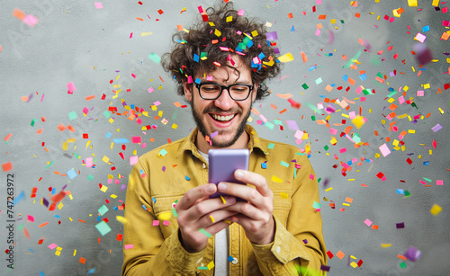 Joyful Smartphone Celebration: Happy Young Man with Confetti