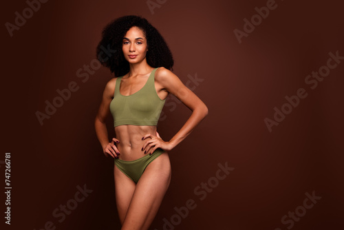 Studio no retouch photo of positive confident lady dressed lingerie enjoying perfect body empty space isolated brown color background © deagreez