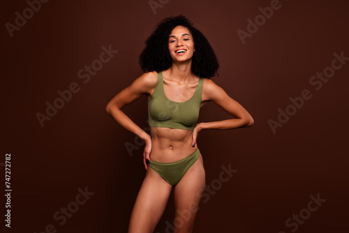 No filter studio photo of shiny cheerful woman wear lingerie enjoying body positive empty space isolated brown color background © deagreez