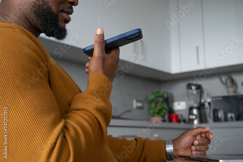 Mid section of man using smart phone in kitchen