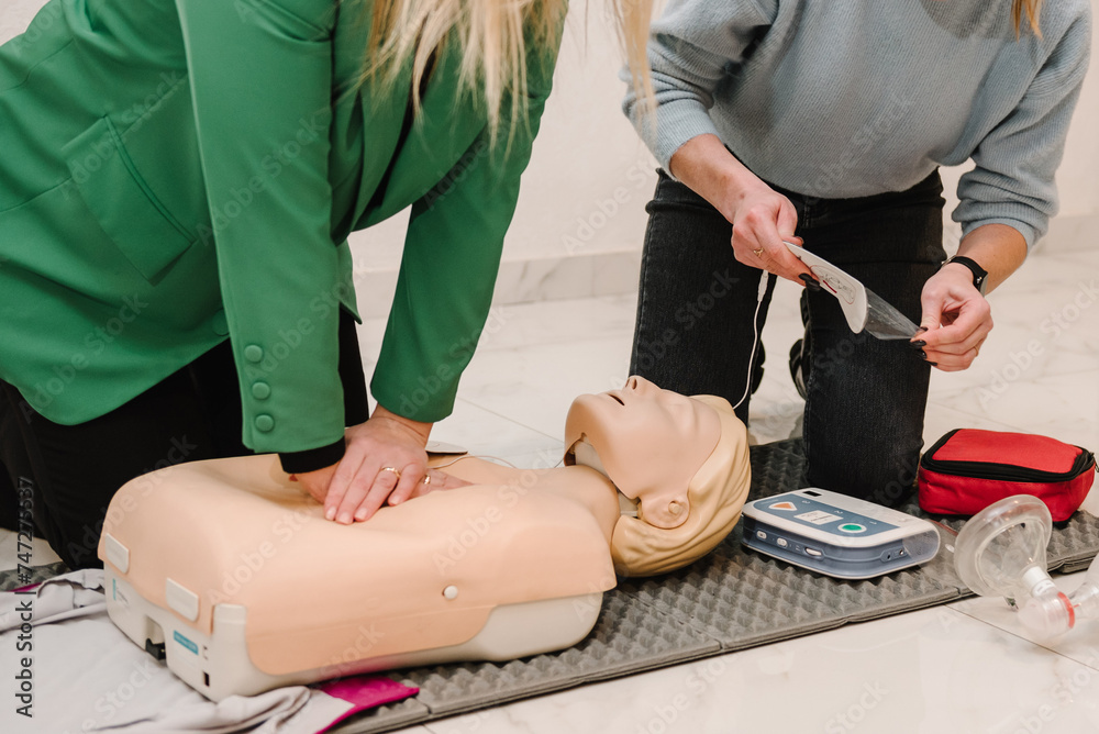 Indirect heart massage. Automated external defibrillator device, AED with training dummy mannequin. Use an automatic defibrillator in conducting basic cardiopulmonary resuscitation of victim. Closeup