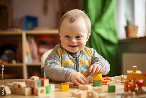 A small child with Down syndrome plays with toys while sitting at the table
