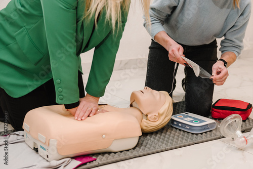 Indirect heart massage. Automated external defibrillator device, AED with training dummy mannequin. Use an automatic defibrillator in conducting basic cardiopulmonary resuscitation of victim. Closeup
