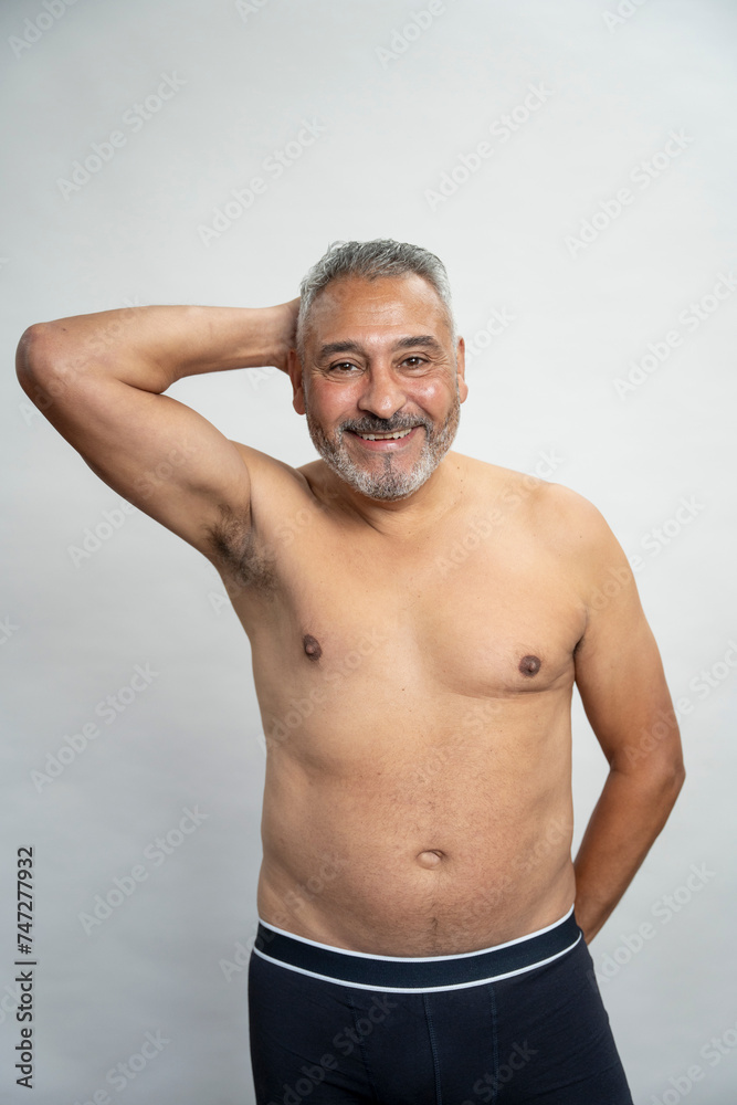 Portrait of smiling senior man without shirt against gray background Portrait of smiling senior man without shirt against gray background