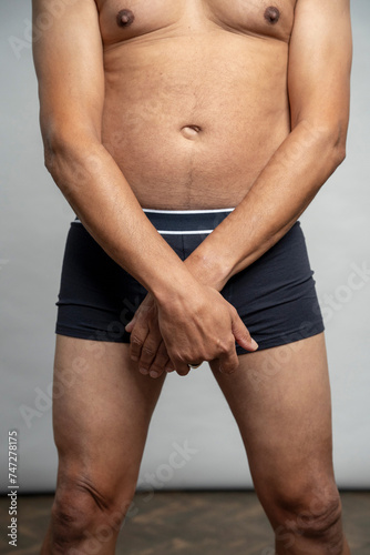 Mid section view of man wearing boxer shorts against gray background