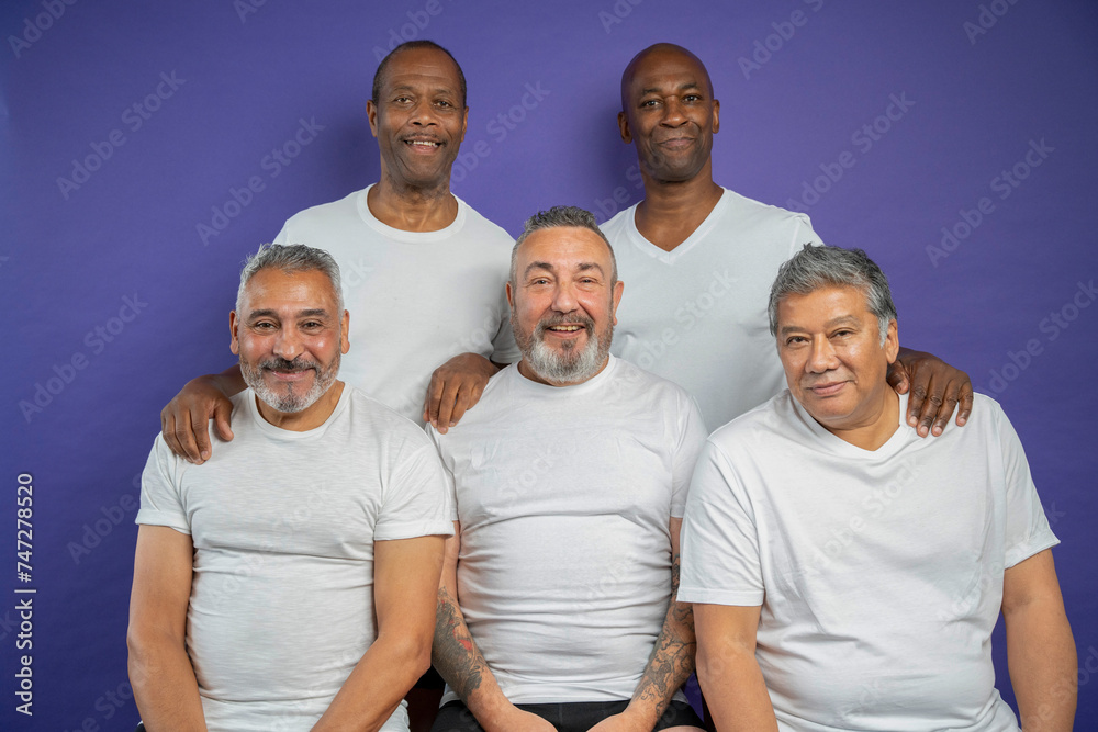 Portrait of smiling senior men against purple background
