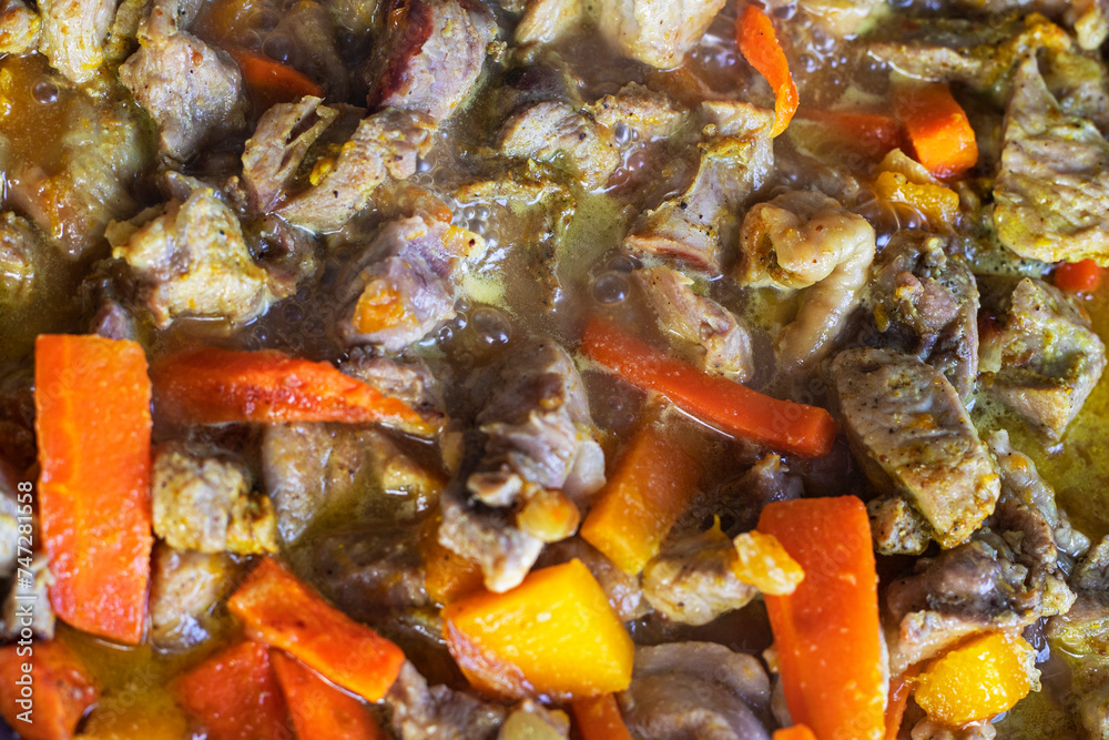 stewing pieces of meat with pumpkin, carrots and onions. view from above stewing pieces of meat with pumpkin, carrots and onions. view from above